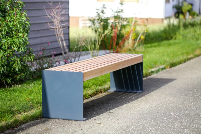 Außenbank aus Metall und Holz steht an öffentlichem Weg