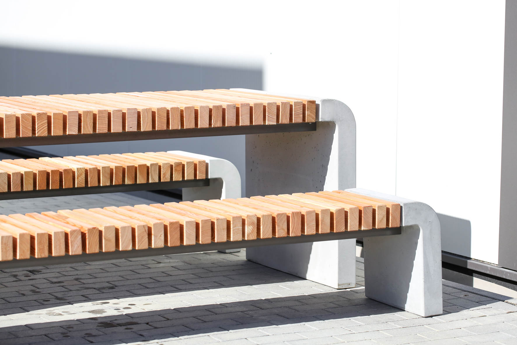 Ensemble Rotundatus avec table et bancs, parfait pour jardins, terrasses et espaces publics. Mélange bois et béton pour durabilité et style moderne