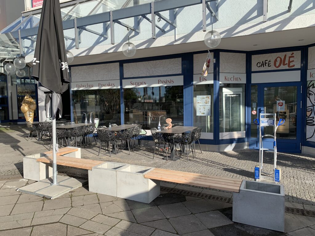 Banc d’angle Primus avec jardinières sur une place publique