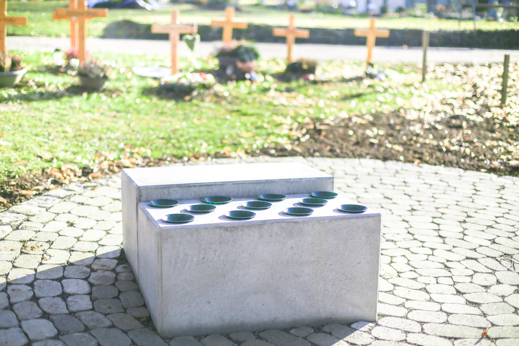 Bloc porte-fleurs en béton avec emplacements pour vases dans un cimetière