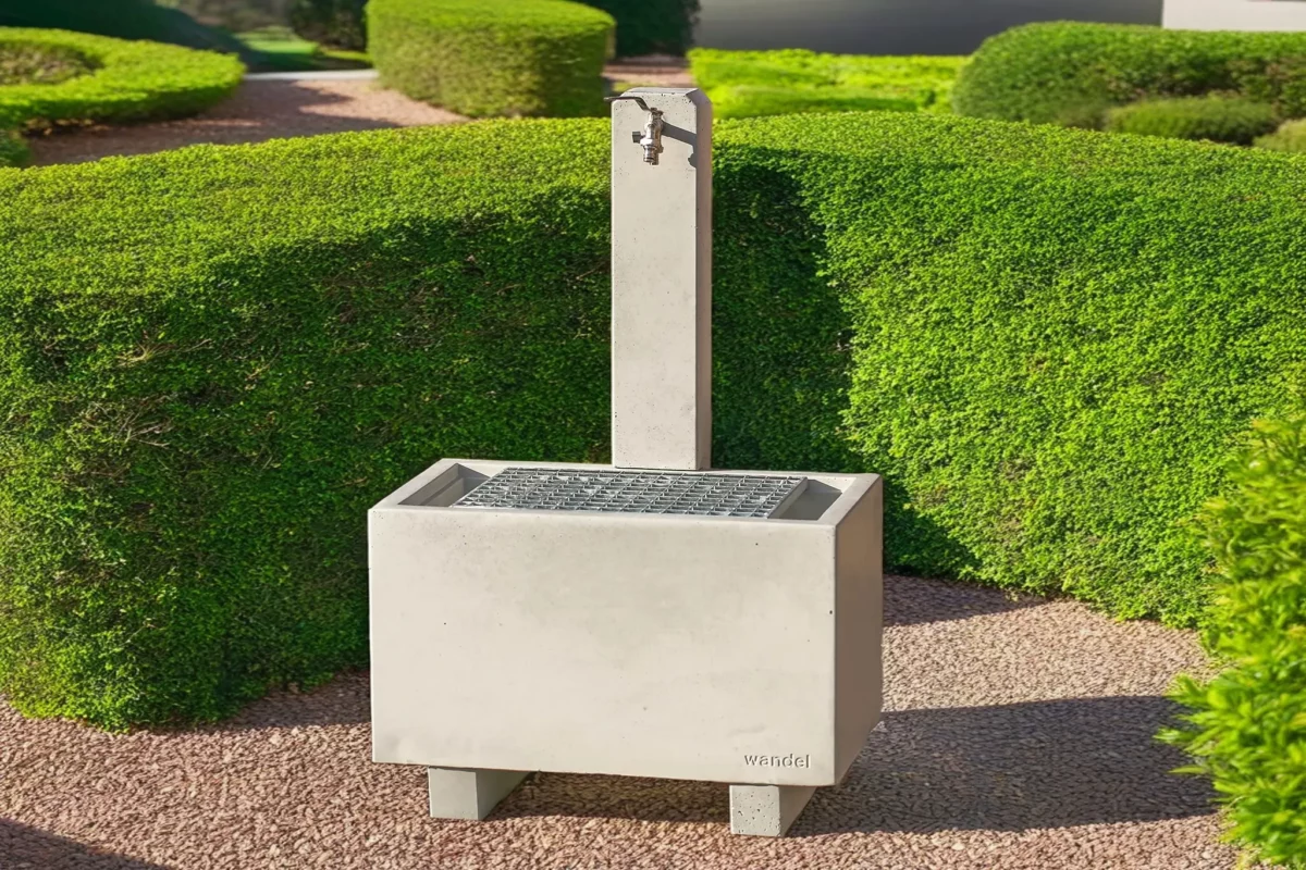 Zapfbrunnen aus Sichtbeton steht auf einem öffentlichen Gelände