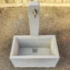 Zapfbrunnen aus Sichtbeton steht auf einem öffentlichen Gelände