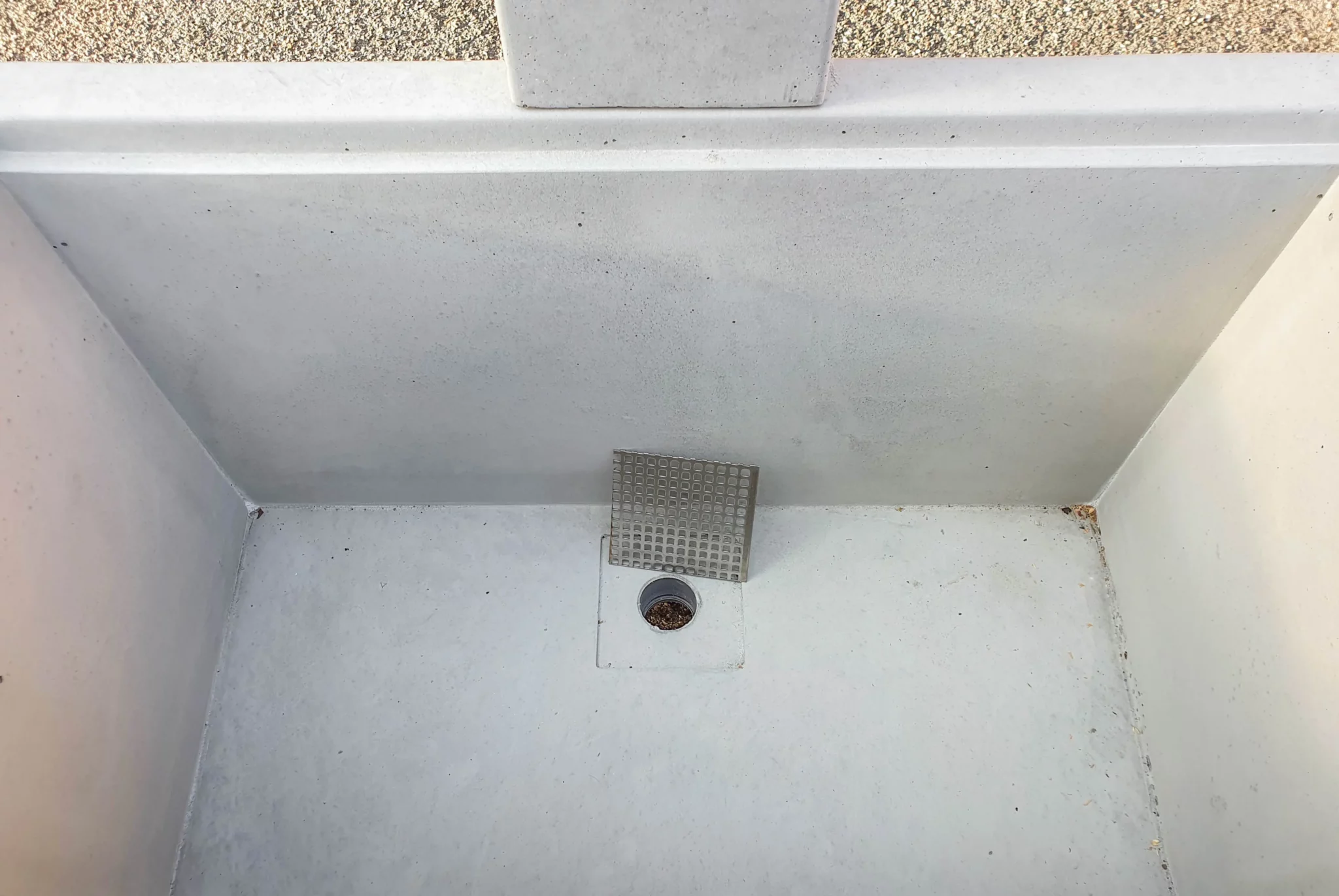 Zapfbrunnen aus Sichtbeton steht auf einem öffentlichen Gelände
