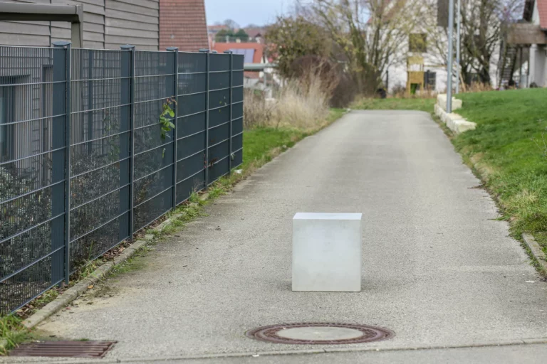 Massiver Poller aus Sichtbeton steht auf öffentlichem Weg zur Durchfahrtsbeschränkung