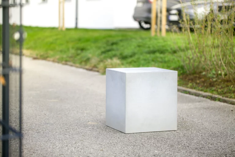 Massiver Poller aus Sichtbeton steht auf öffentlichem Weg zur Durchfahrtsbeschränkung