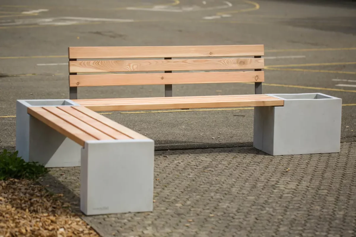 Eckbank aus Beton und Lärchenholz steht auf öffentlichem Platz