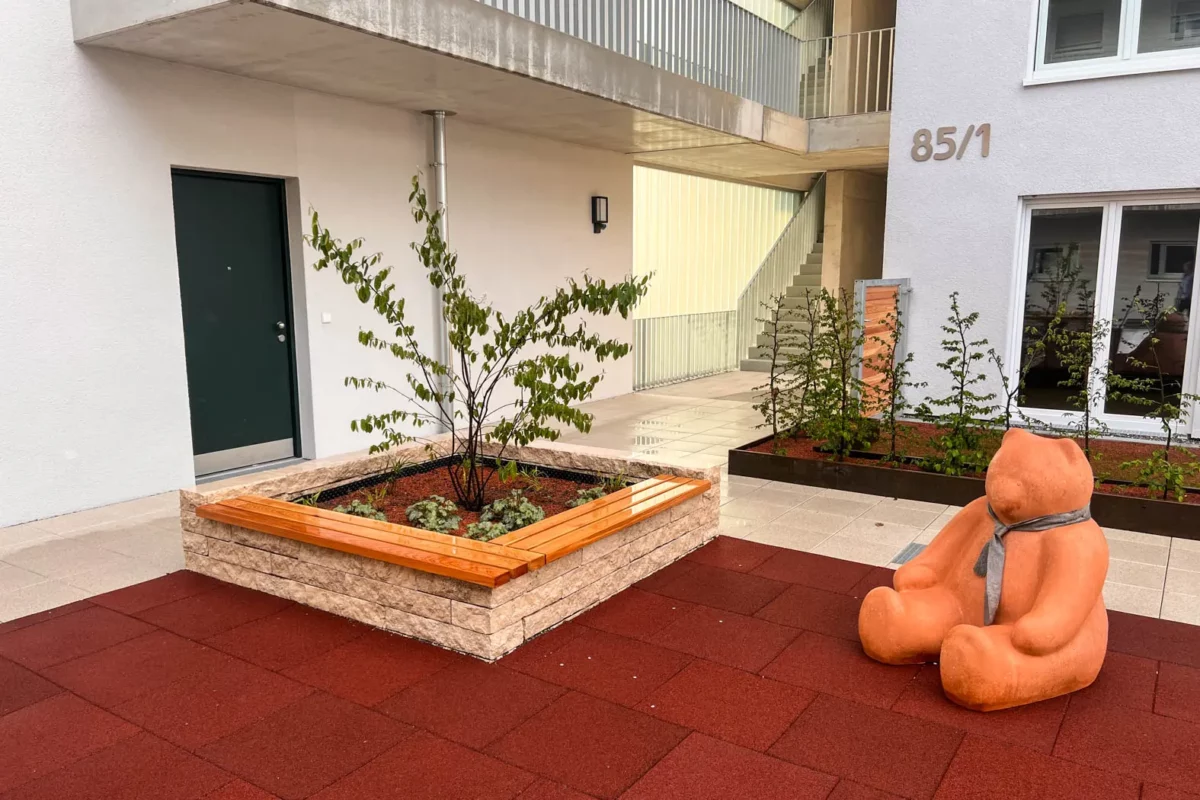 Mauerauflage aus Lärchenholz platziert auf Steinmauer vor öffentlichem Gebäude