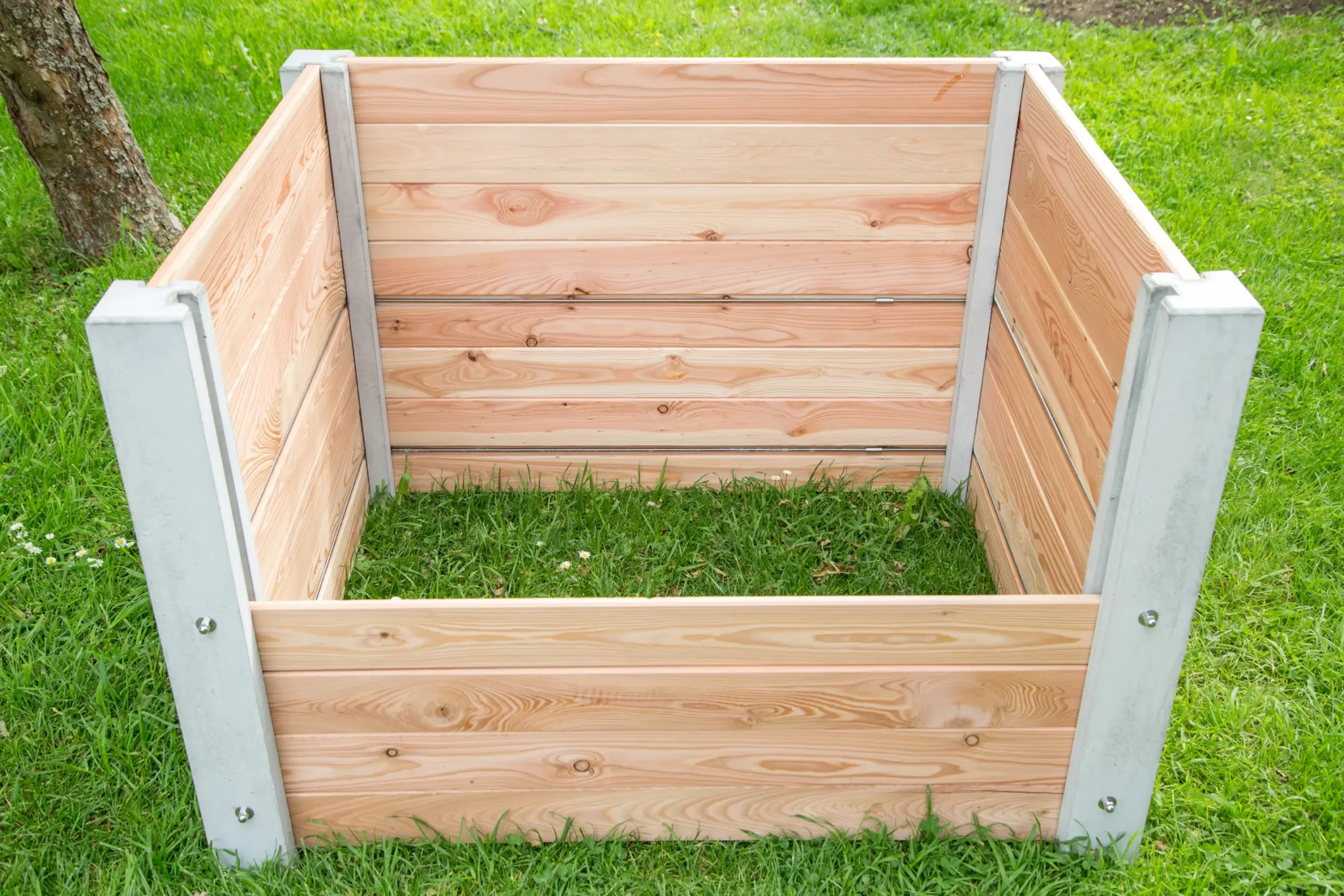 Hochbeet aus Beton und Lärchenholz steht auf Rasenfläche