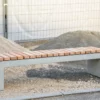 Massive Sitzbank aus Sichtbeton, optional mit Sitzauflage aus Holzdielen, steht in öffentlichem Bereich
