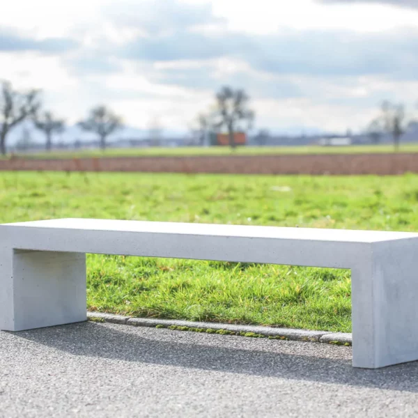 Massive Sitzbank aus Sichtbeton, optional mit Sitzauflage aus Holzdielen, steht in öffentlichem Bereich