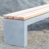 Massive Sitzbank aus Sichtbeton, optional mit Sitzauflage aus Holzdielen, steht in öffentlichem Bereich