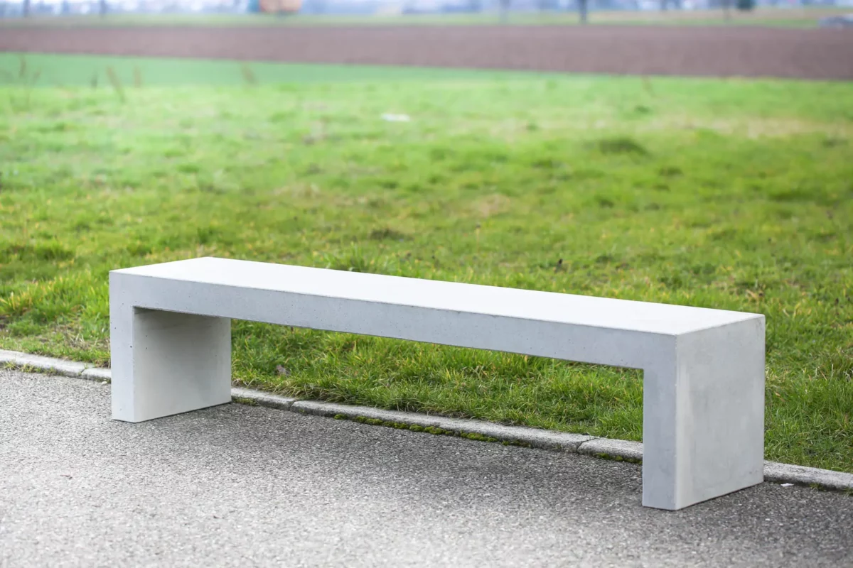 Massive Sitzbank aus Sichtbeton, optional mit Sitzauflage aus Holzdielen, steht in öffentlichem Bereich