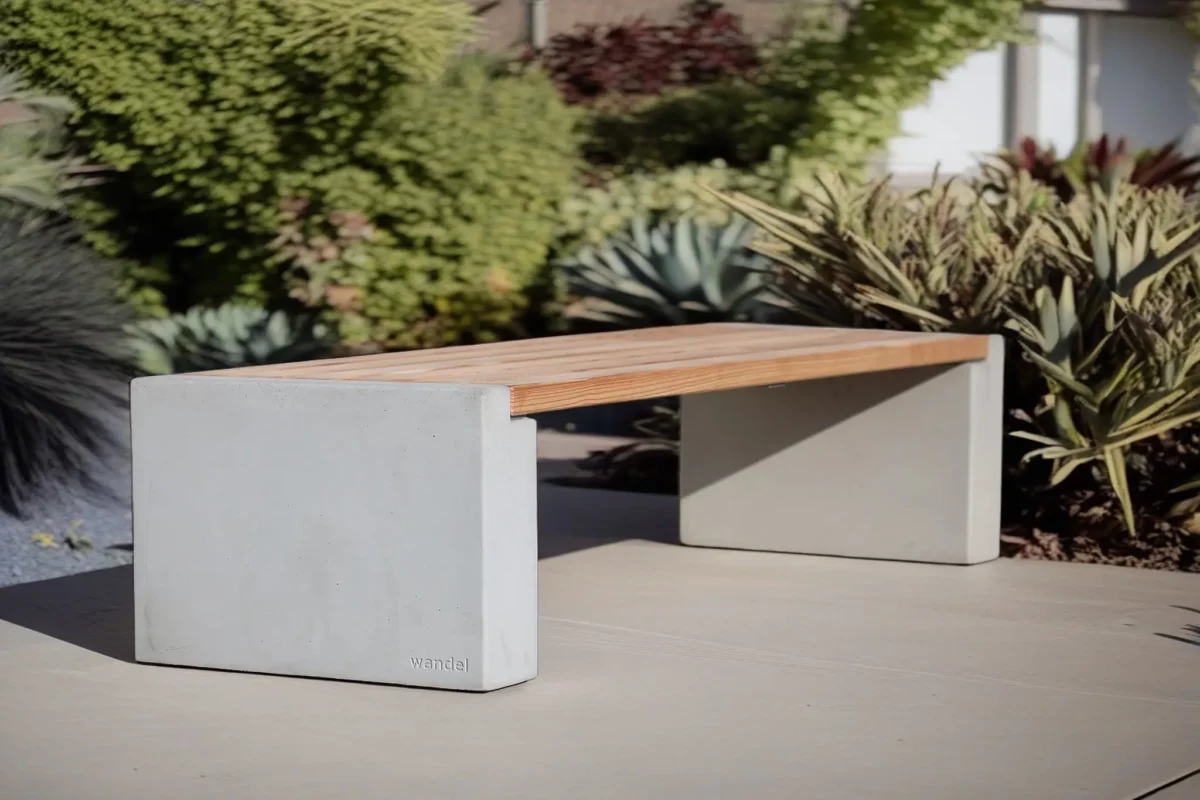 Sitzbank in Überbreite aus Beton und Lärchenholz steht auf einer öffentlichen Fläche